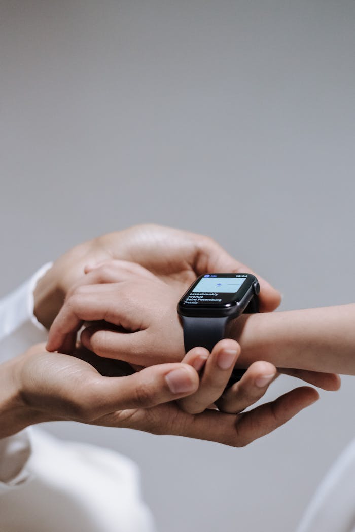 Close-up of a parent helping a child use a smartwatch, emphasizing digital connectivity and support.